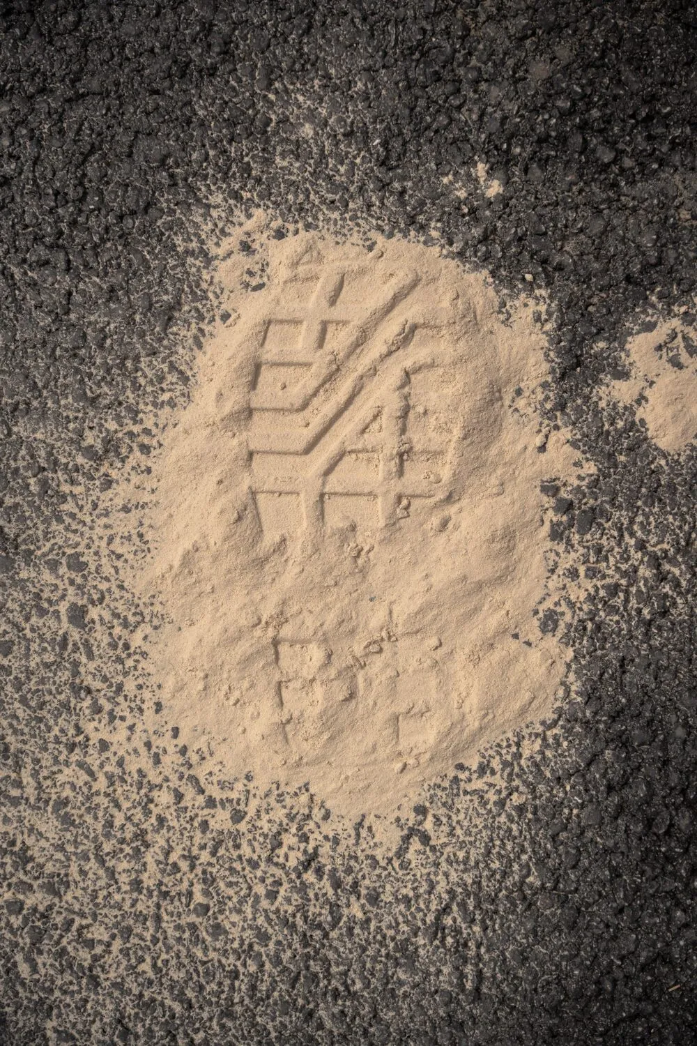 Abdruck eines Reifenprofils in hellem HEMPLIZIT-Pulver auf Asphalt
